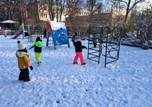 Zdjęcie przedstawia dzieci biegające po śniegu.