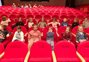 Zdjęcie przedstawia dzieci siedzące w teatrze.