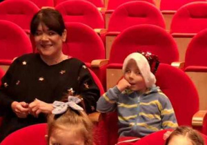 na zdjęciu widać dzieci siedzące w teatrze