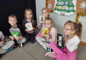 Na zdjęciu widzimy grupkę dzieci, które trzymają w ręku stworzone przez siebie kartki świąteczne dla podopiecznych Fundacji "Mam Marzenie".