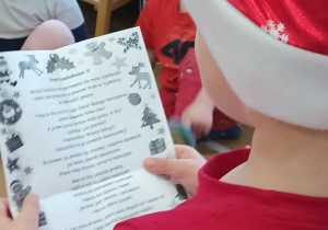 Chłopiec czyta list od Świętego Mikołaja wszystkim dzieciom.