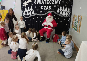 Na zdjęciu widzimy Św. Mikołaja oraz dzieci które siędzą wokół Niego.