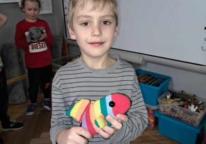 Zdjęcie przedstawia chłopca ze swoją zabawką zrobioną przez rodziców.