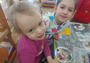 Zdjęcie przedstawia dwie dziewczynki układające suszki