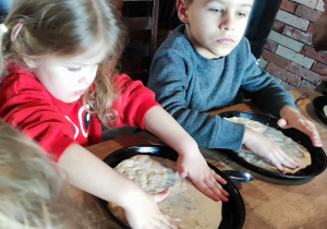 Dzieci przygotowują spód pizzy