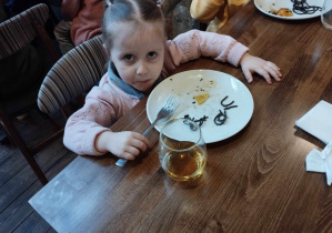Na zdjęciu widzimy dziewczynkę, która próbuje makaronu w kształcie ślimaka.