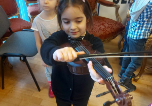 Dziewczynka próbująca grać na skrzypcach
