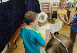 Zdjęcie przedstawia dzieci tańczące w parach. Dzieci przebrane są w stroje.