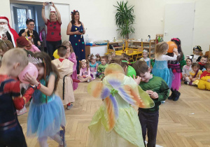 Na zdjęciu widzimy dzieci, które uczestniczą w zabawie. Trzymają kolorowe balony między swoimi czołami.
