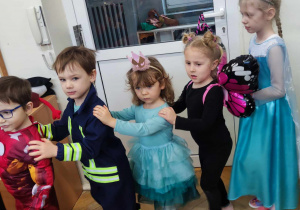 Na zdjęciu widzimy grupkę dzieci, które biorą udział w zabawie i tańczą do piosenki "Jedzie pociąg".