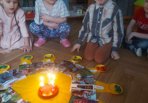 Zdjęcie przedstawia urodzinowe słoneczko i jubilata dmuchającego świeczki