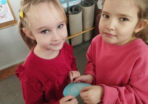 Na zdjęciu widzimy dwie dziewczynki, które z dwóch połówek tworzą serce.