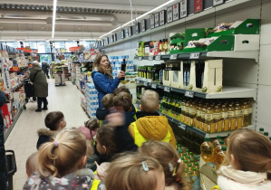 Na zdjęciu widzimy nauczycielkę, która pokazuje dzieciom oliwę z oliwek z Włoch.