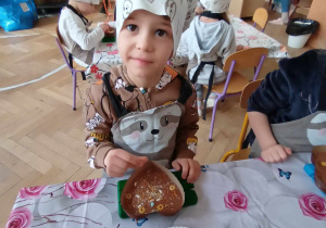 Chłopiec siedzi przy stole i tworzy swoją własną czekoladę.