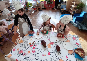 Dzieci siedzą przy stole i tworzą swoją własną czekoladę.