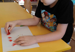 Zdjęcie przedstawia chłopca, który siedzi przy stole i rysuje.