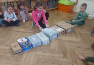 Dzieci które układają pudełka od największego do najmniejszego
