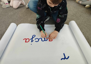 Na zdjęciu widzimy chłopca, który obrysowuje literę "a" z ruchomego alfabetu tworząc napis "Francja".