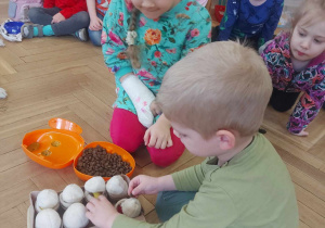 Zdjęcie przedstawia dzieci, które chowają Lili chrupki do jajek