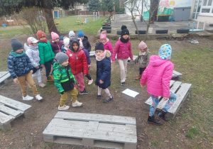 Grupa dzieci w ogrodzie przedszkolnym podczas wykonywania ćwiczeń oddechowych