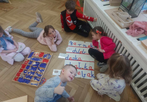 Grupa dzieci podczas tworzenia wyrazów z ruchomego alfabetu