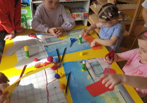Dzieci wykonujące prace plastyczne o tematyce kolorowych skarpetek.