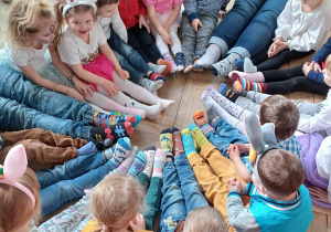 Dzieci oglądające swoje kolorowe skarpetki.