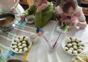 Na zdjęciu widzimy dzieci, które jedzą wielkanocny żurek z jajkiem.