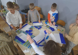 Zdjęcie przedstawia dzieci wykonujące pracę plastyczną.