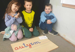 Dzieci układają napis - autyzm.