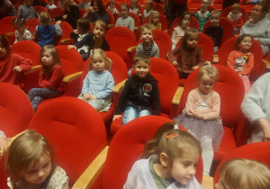 na zdjęciu widać dzieci siedzące na widowni