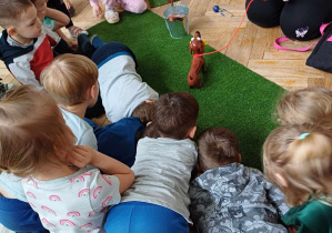 Dzieci bawią sią zabawką - pies robiący kupy