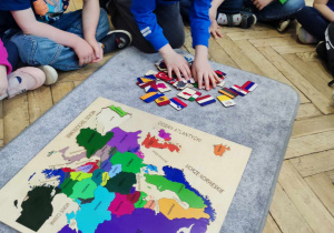 Dzieci szukają na mapie Hiszpanii i jej flagi