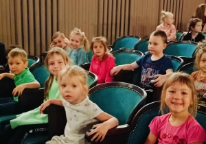 Dzieci siedzą na widowni w tatrze.