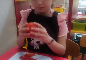 Dziewczynka obiera pomidora