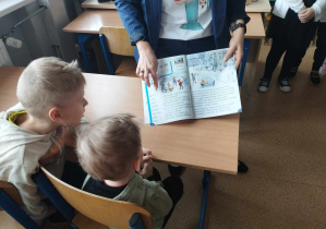 Na zdjęciu widzimy chłopców, którzy patrzą w książkę do czytania dla dzieci z klasy I.