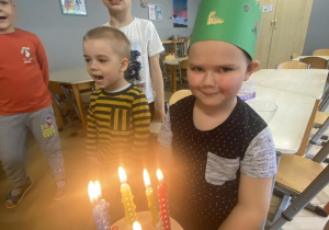 Zdjęcie przedstawia chłopca przy torcie ze świeczkami.