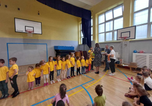 Zdjęcie przedstawia dzieci ustawione w rzędzie oraz Panią Dyrektor oraz organizatorki wręczające dzieciom medale.