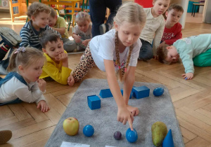 chłopiec dopasowuje bryły do owoców