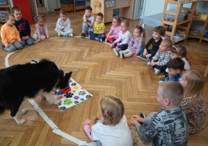 Pies pije wode naszykowana przez dzieci