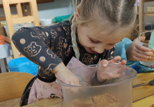 Dzieci nakładają spód z ciastek i masła do szklaneczek