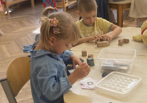 Zdjęcie przedstawia dzieci budujące z klocków.