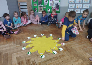 Na zdjęciu widzimy solenizanta, który wkłada do miseczek koraliki oznaczające poszczególne lata.