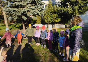 Na zdjęciu widzimy grupkę dzieci, które witają się z p. Alicją - prowadzącą zajęcia edukacyjne.