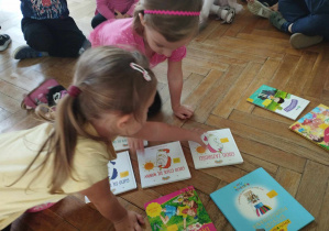 Na zdjęciu widzimy dziewczynki, które decydują samodzielnie, którą książkę chcą wypożyczyć na weekend do domu.