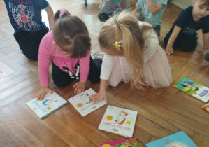 Na zdjęciu widzimy dziewczynki, które decydują samodzielnie, którą książkę chcą wypożyczyć na weekend do domu.