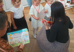 Zdjęcie przedstawia dzieci stojące w szeregu z medalami na szyi.