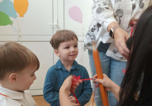 Zdjęcie przedstawia chłopca i kobietę trzymającą medal w ręku.