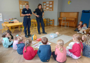 dwie panie ze straży miejskiej stoja przed grupą dzieci