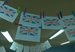 Zdjęcie przedstawia zawieszone pokolorowane przez dzieci flagi Wielkiej Brytanii.